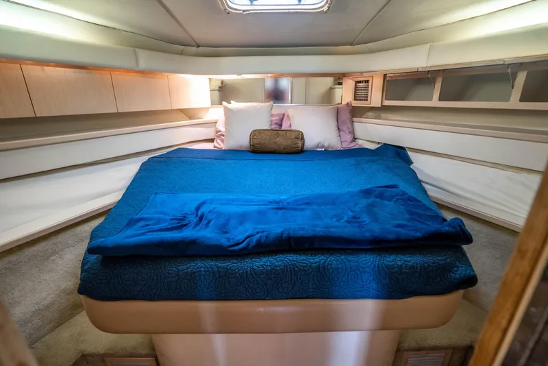 Slide: The Image of Cozy cabin interior of 1995 Tiara Yachts 4300 Open with blue bedding. - 30