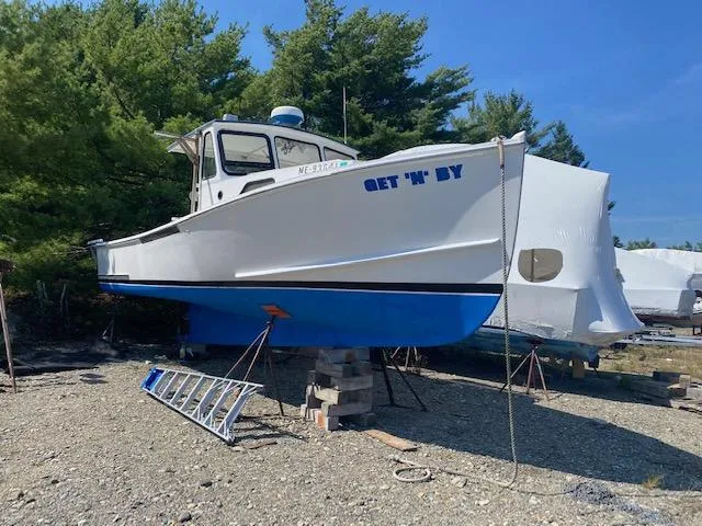 Slide: The Image of Crowley-Beal 28 boat from 1996 named "Get 'N' By" on dry dock. - 2