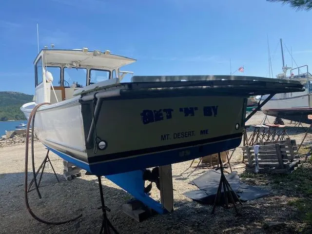 Slide: The Image of Crowley-Beal 28 boat from 1996 on stands, Mt. Desert, ME, under clear blue sky. - 7