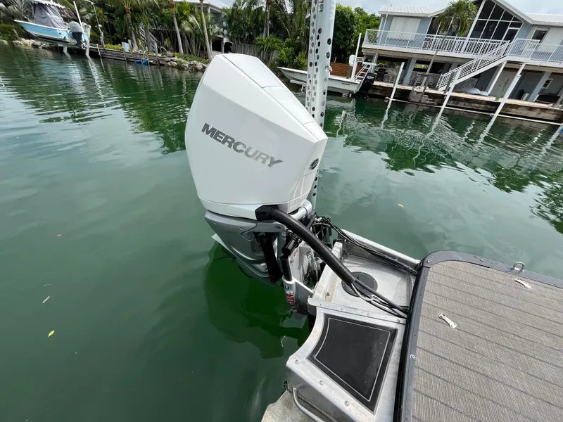 Slide: The Image of Mercury outboard motor on 2021 Tahoe Grand Tahoe ELW boat docked by waterfront homes. - 13