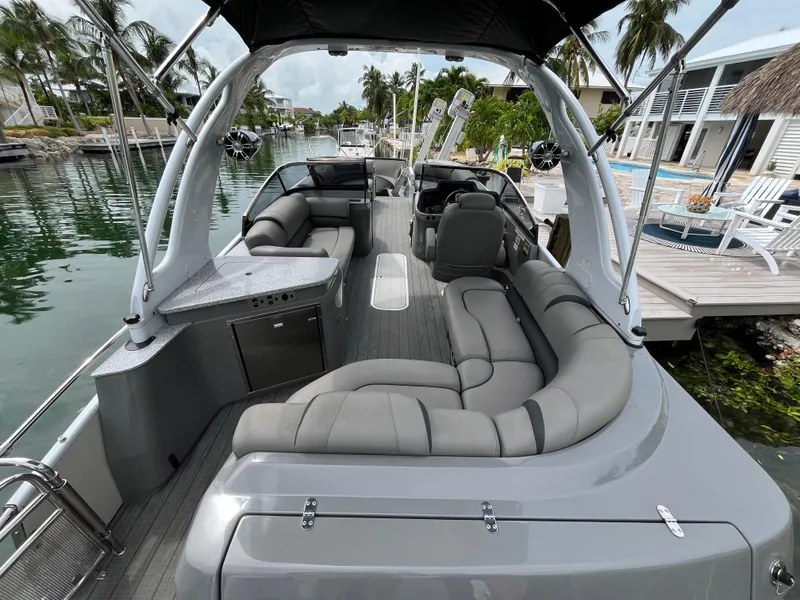 Slide: The Image of 2021 Tahoe Grand Tahoe ELW boat with spacious seating on a scenic canal. - 21