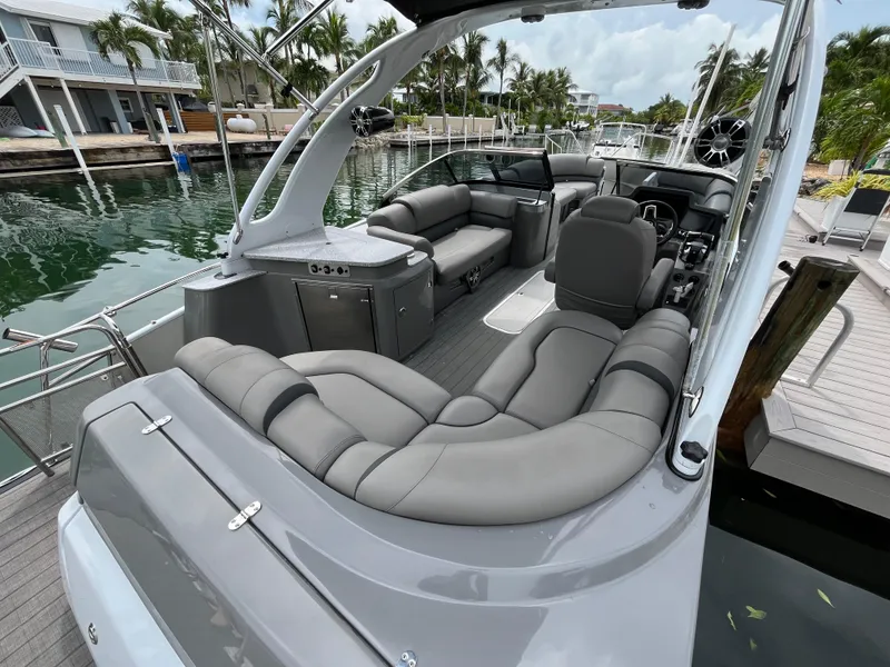 Slide: The Image of 2021 Tahoe Grand Tahoe ELW boat with luxurious seating docked by palm trees. - 22