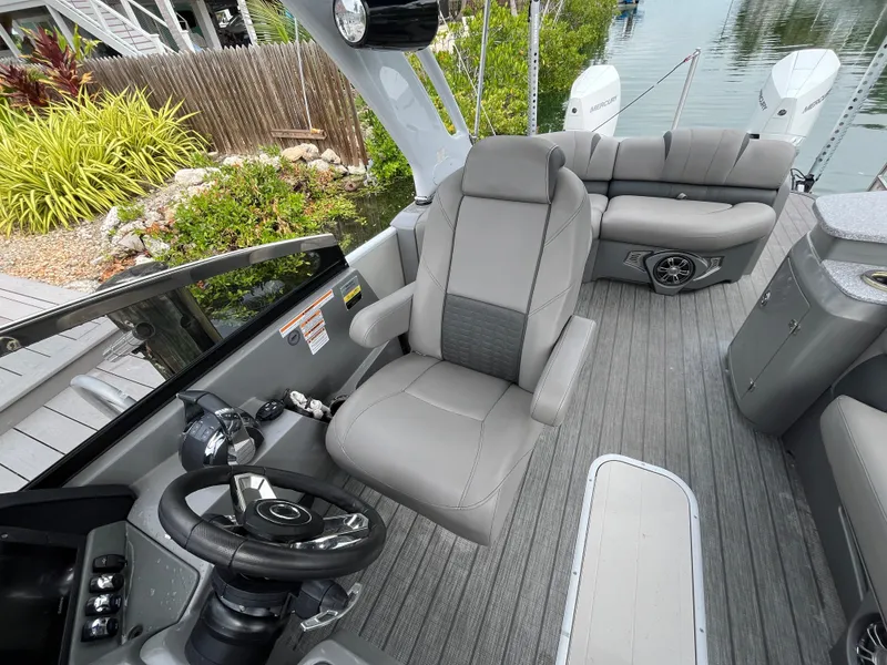 Slide: The Image of 2021 Tahoe Grand Tahoe ELW boat interior with plush seating and modern steering console. - 30