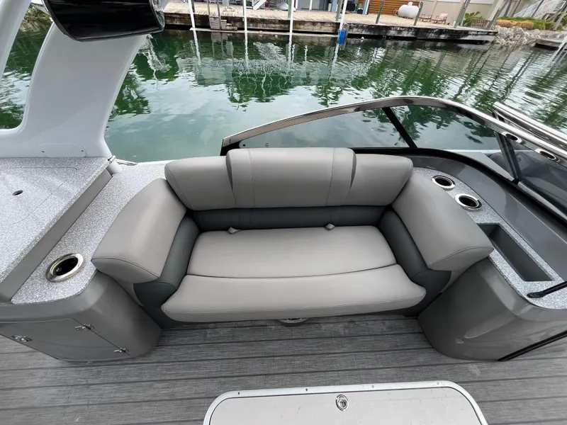 Slide: The Image of 2021 Tahoe Grand Tahoe ELW boat with gray seating and cup holders by the water. - 34