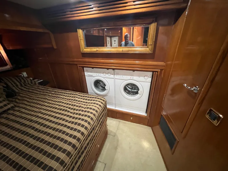 Slide: The Image of Laundry area in 2001 Carver 530 Voyager yacht bedroom with wood paneling and plaid bedding. - 15