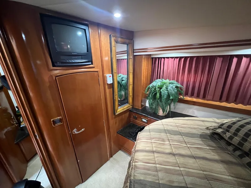Slide: The Image of Luxurious 2001 Carver 530 VOYAGER cabin with TV, mirror, and potted plant. - 6