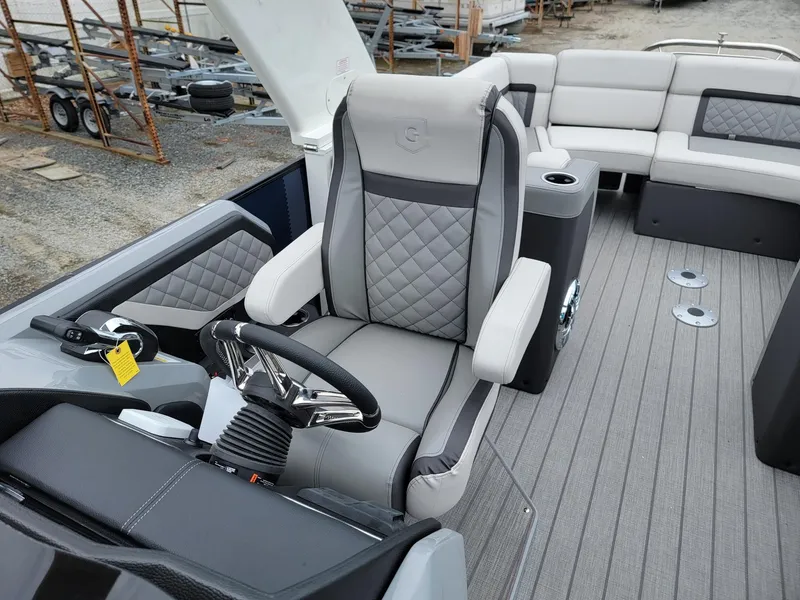 Slide: The Image of 2025 Godfrey AquaPatio 255 ULC boat interior with luxurious seating and modern steering console. - 11