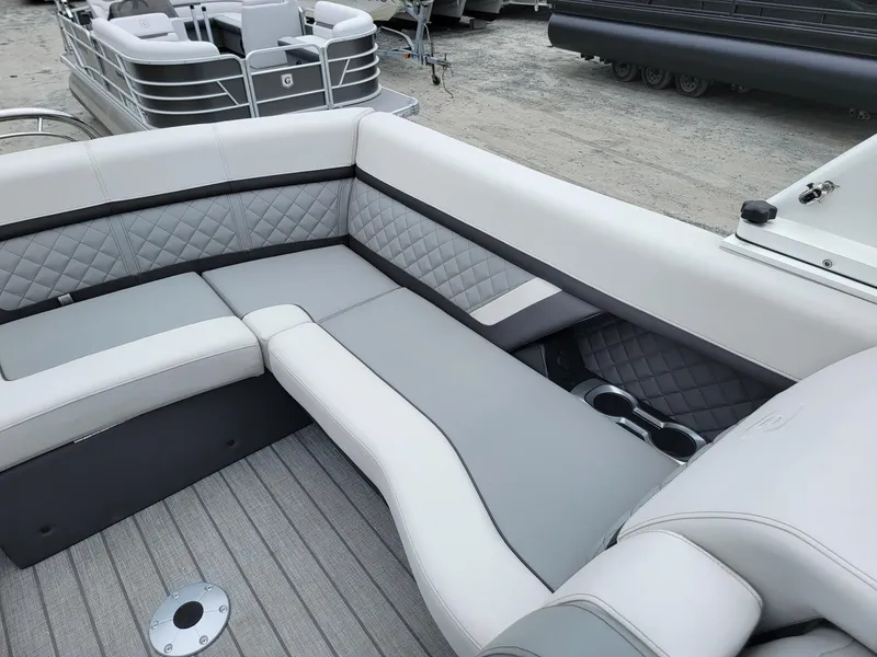 Slide: The Image of 2025 Godfrey AquaPatio 255 ULC boat interior with gray quilted seating and cup holders. - 15