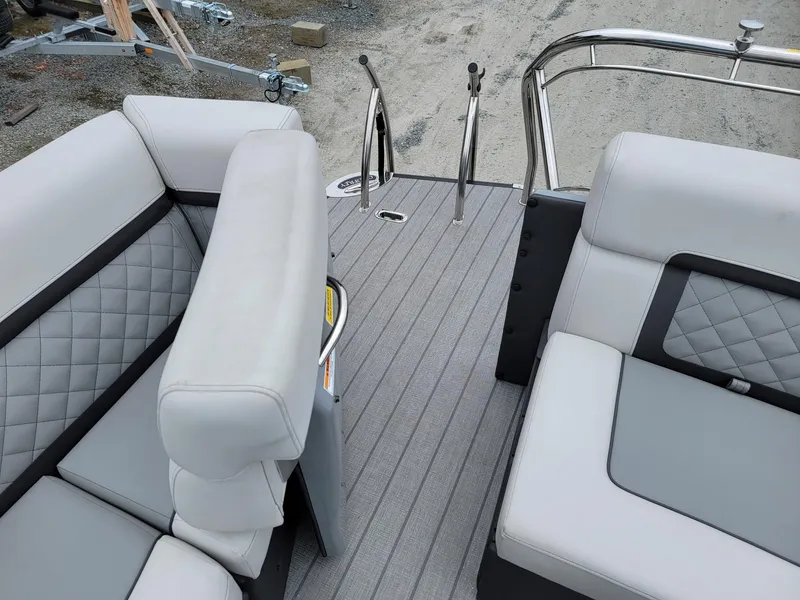 Slide: The Image of 2025 Godfrey AquaPatio 255 ULC boat interior with gray seating and deck. - 18