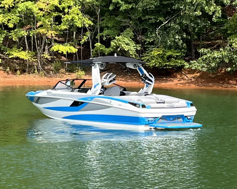 Slide: The Image of 2025 Centurion Fe23 boat on a serene lake with lush green forest backdrop. - 3