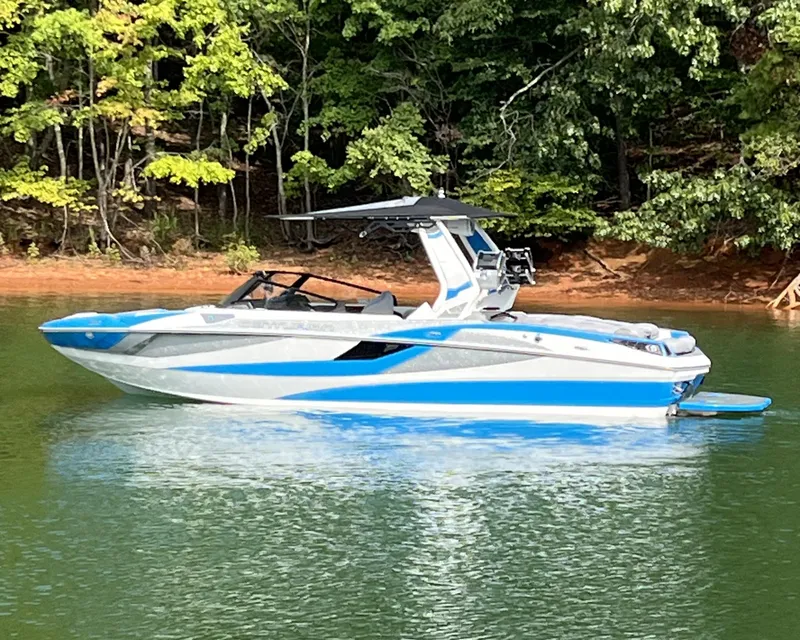 Slide: The Image of 2025 Centurion Fe23 boat on a calm lake with forested background. - 5