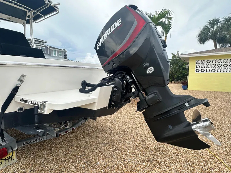 Slide: The Image of 2017 May-Craft 2300CCX boat with Evinrude outboard motor on gravel driveway. - 11
