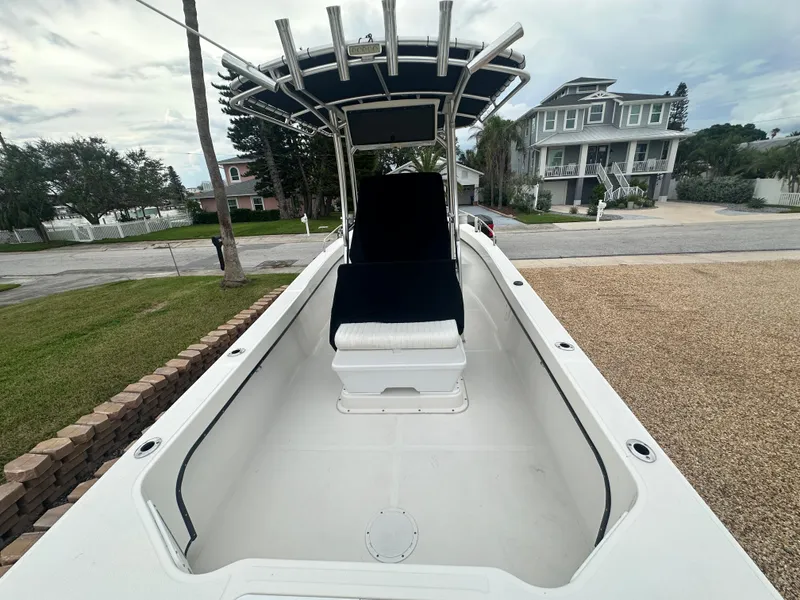 Slide: The Image of 2017 May-Craft 2300CCX boat with center console and T-top, parked in residential area. - 18