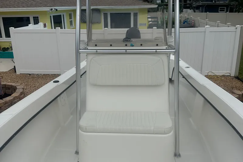 Slide: The Image of 2017 May-Craft 2300CCX boat with center console and seating, docked near a house. - 24
