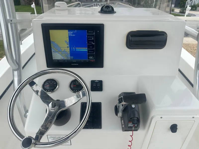Slide: The Image of 2017 May-Craft 2300CCX boat console with steering wheel and navigation display. - 38