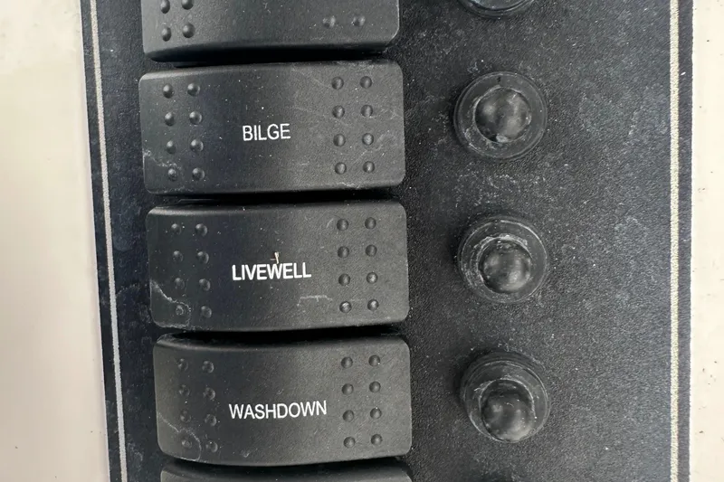 Slide: The Image of Control panel switches on a 2017 May-Craft 2300CCX boat. - 41