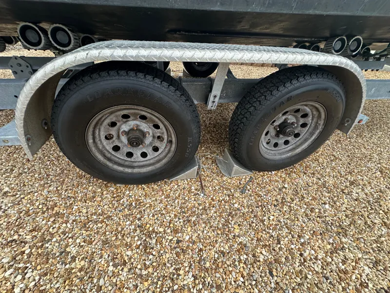 Slide: The Image of Trailer wheels for 2017 May-Craft 2300CCX boat on gravel surface. - 48