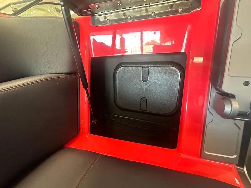 Slide: The Image of 2025 Supra SA 450 interior storage compartment with red trim and black seating. - 17