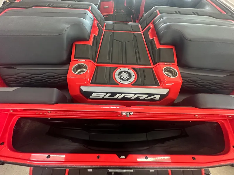 Slide: The Image of 2025 Supra SA 450 boat interior with red and black seating and storage area. - 33