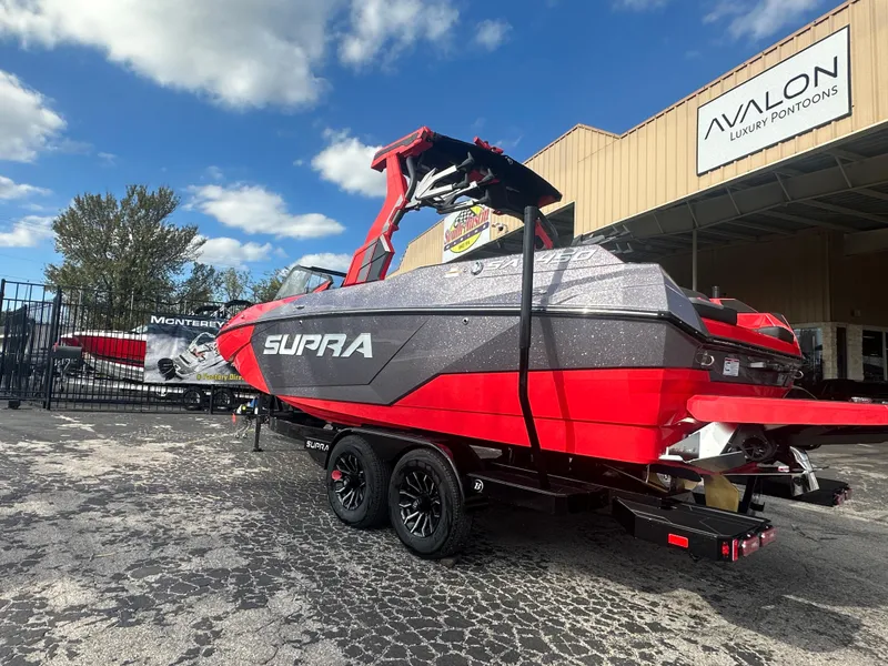 Slide: The Image of 2025 Supra SA 450 boat in red and gray, parked outside Avalon Luxury Pontoons. - 5