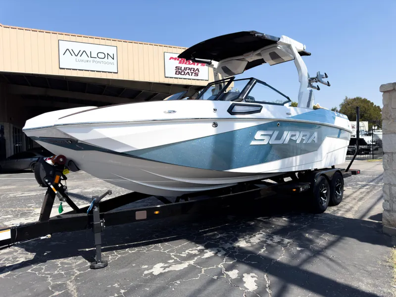 The Image of 2025 Supra SL 550 boat on trailer outside dealership. - 1