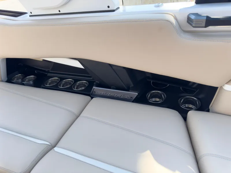 Slide: The Image of 2025 Supra SL 550 interior with beige leather seats and cup holders. - 27