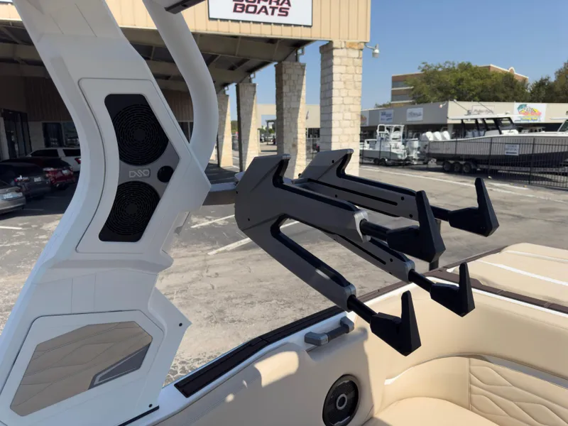 Slide: The Image of 2025 Supra SL 550 boat with wakeboard rack and speakers, parked at a dealership. - 35
