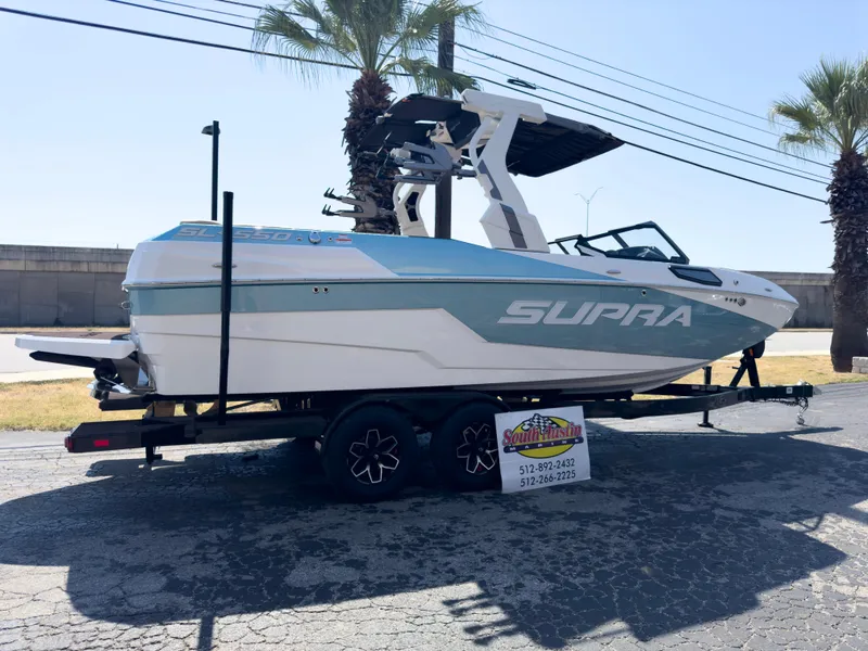Slide: The Image of 2025 Supra SL 550 boat on trailer, parked outdoors under palm trees. - 4