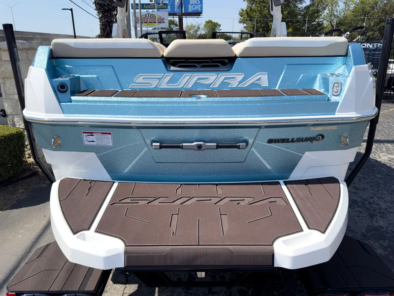 Slide: The Image of 2025 Supra SL 550 boat, blue and white, rear view with swim platform. - 5
