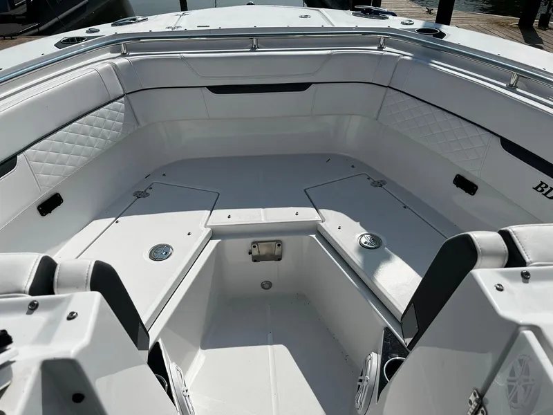 Slide: The Image of 2023 Blackfin 272 DC boat interior with white seating and storage compartments. - 23