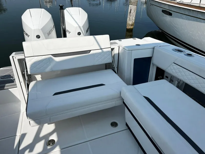 Slide: The Image of 2023 Blackfin 272 DC boat interior with white seating and dual Mercury engines. - 28