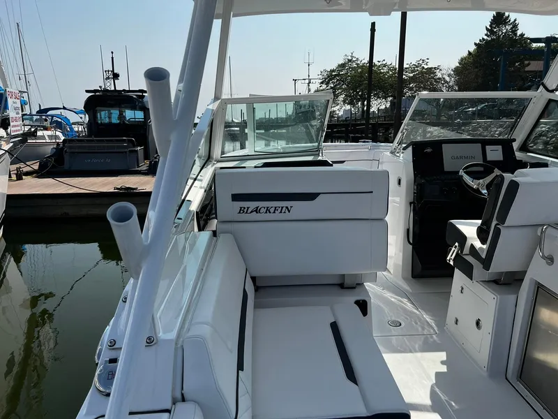 Slide: The Image of 2023 Blackfin 272 DC boat interior at marina, featuring sleek seating and helm. - 33