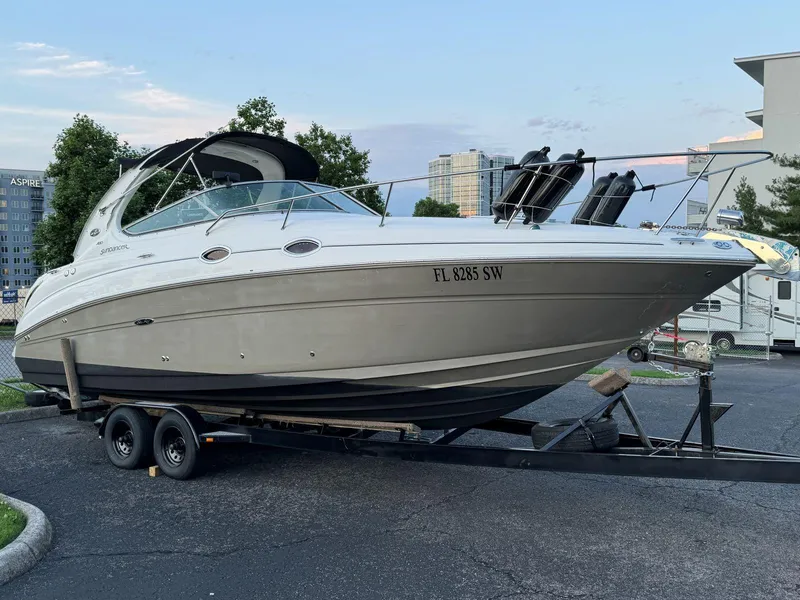 The Image of 2006 Sea Ray 280 Sundancer boat on trailer in urban setting. - 1