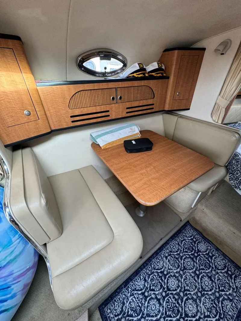 Slide: The Image of 2006 Sea Ray 280 Sundancer cabin with dining area and wooden cabinetry. - 24