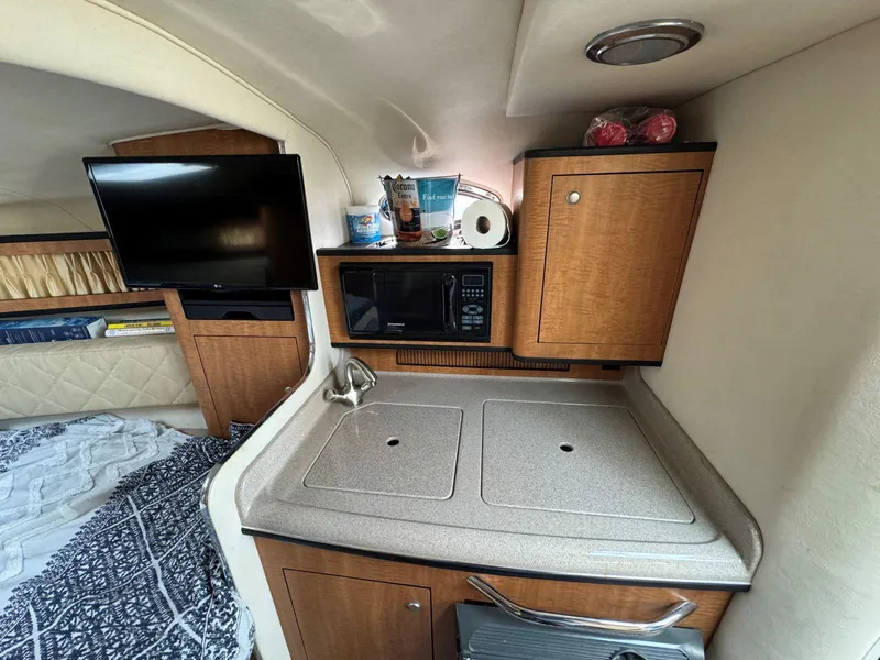 Slide: The Image of 2006 Sea Ray 280 Sundancer cabin with kitchenette, microwave, and TV. - 27