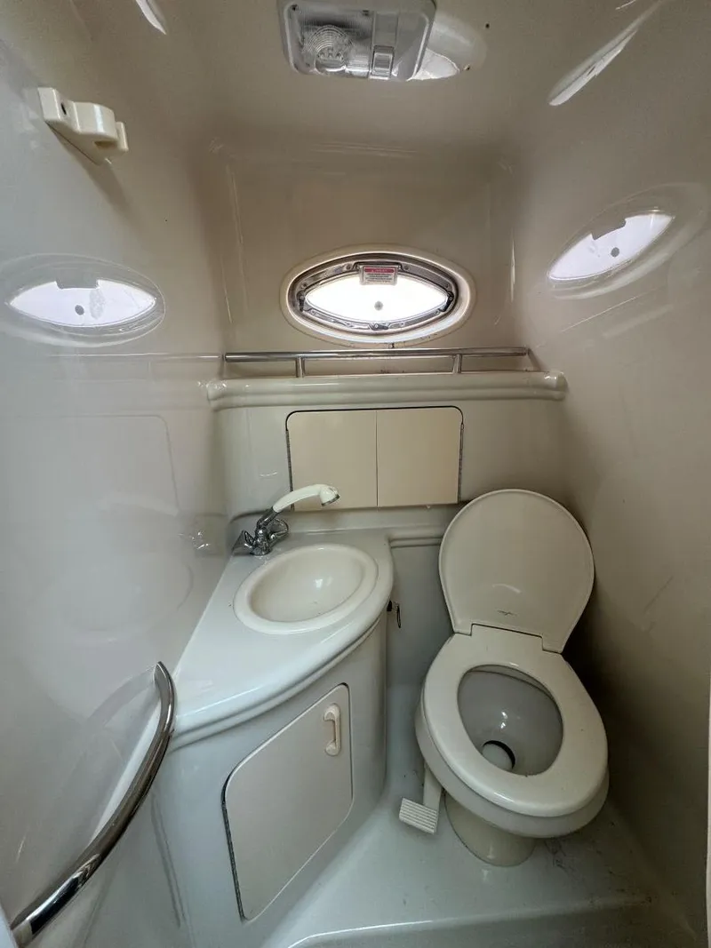 Slide: The Image of 2006 Sea Ray 280 Sundancer bathroom with sink, toilet, and porthole window. - 28