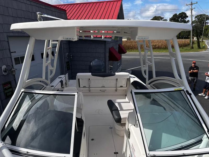 Slide: The Image of 2019 Robalo R247 Dual Console boat with open deck and seating, parked near a building. - 11