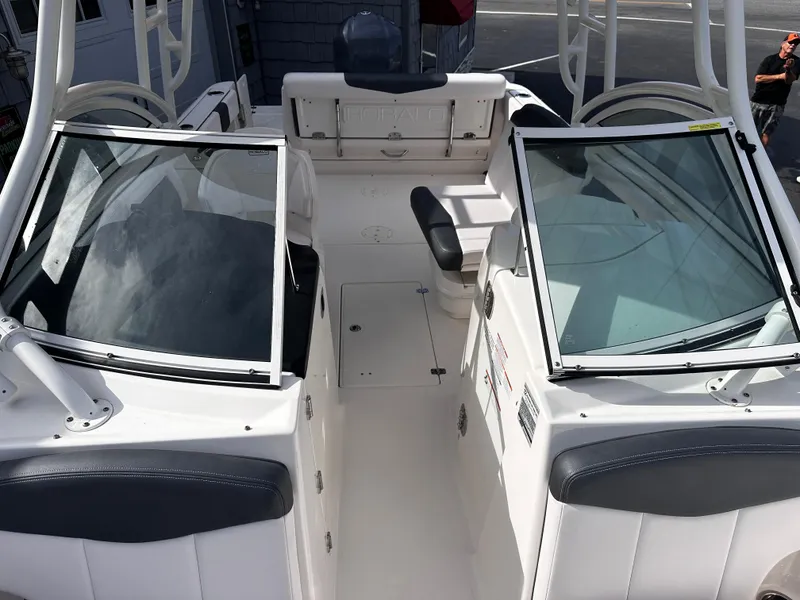 Slide: The Image of 2019 Robalo R247 Dual Console boat interior with open windshield and seating. - 12