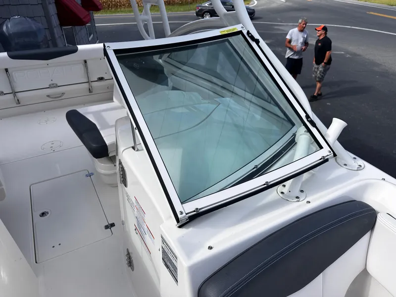 Slide: The Image of 2019 Robalo R247 Dual Console boat interior with windshield and seating. - 15