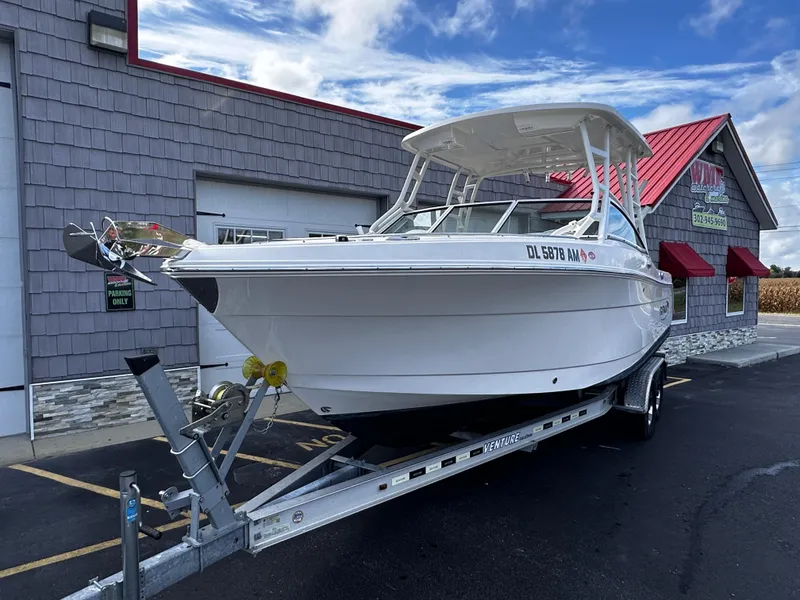 Slide: The Image of 2019 Robalo R247 Dual Console boat on trailer outside a building. - 2