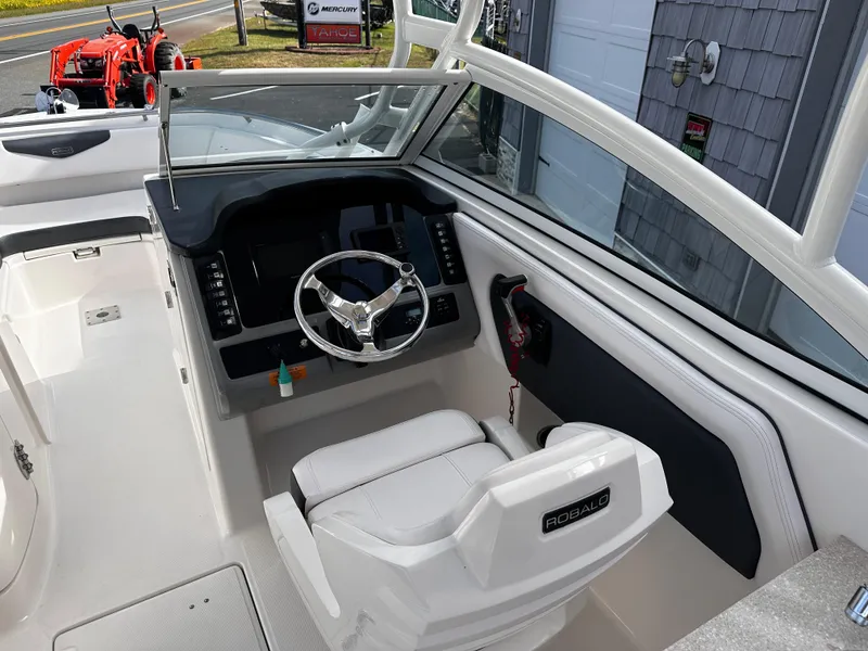 Slide: The Image of 2019 Robalo R247 Dual Console boat cockpit with steering wheel and seating. - 22