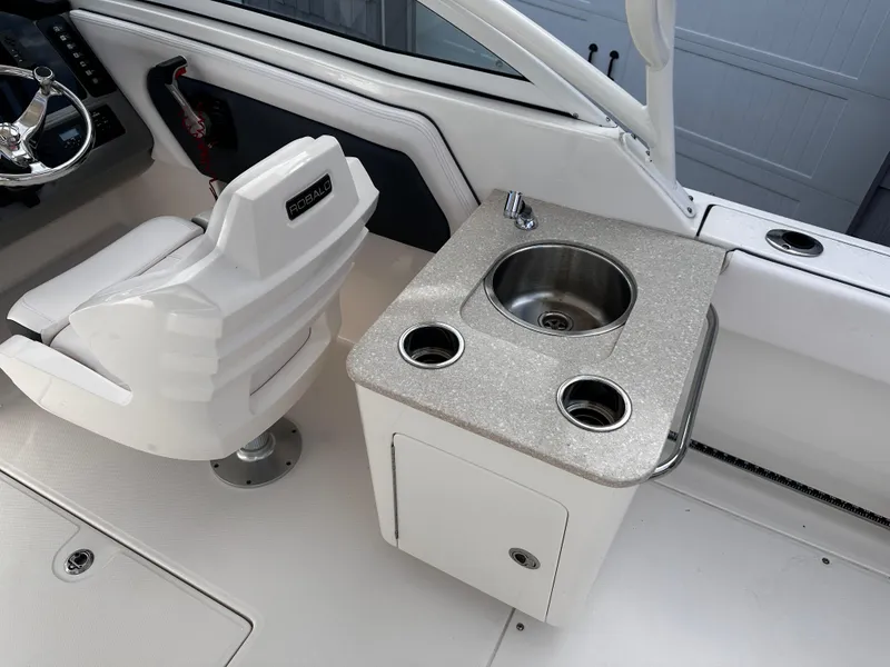 Slide: The Image of 2019 Robalo R247 Dual Console boat interior with sink and captain's chair. - 24
