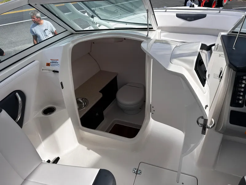 Slide: The Image of 2019 Robalo R247 Dual Console boat interior with compact bathroom. - 26