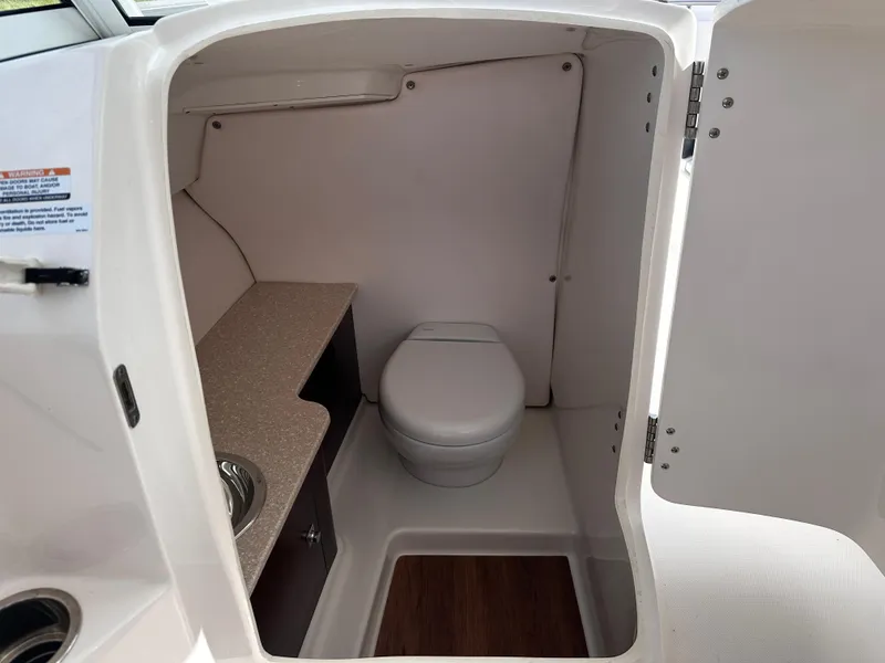 Slide: The Image of 2019 Robalo R247 Dual Console boat interior bathroom with toilet and sink. - 27