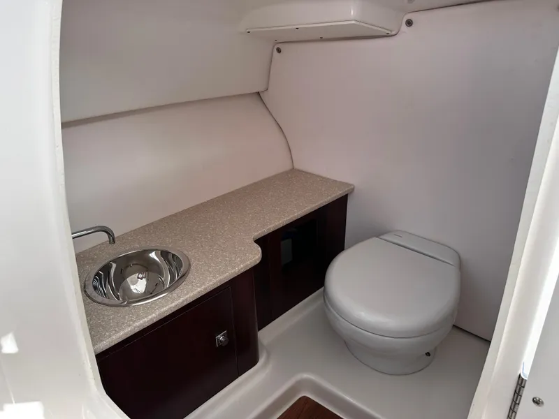 Slide: The Image of 2019 Robalo R247 Dual Console boat bathroom with sink and toilet. - 28
