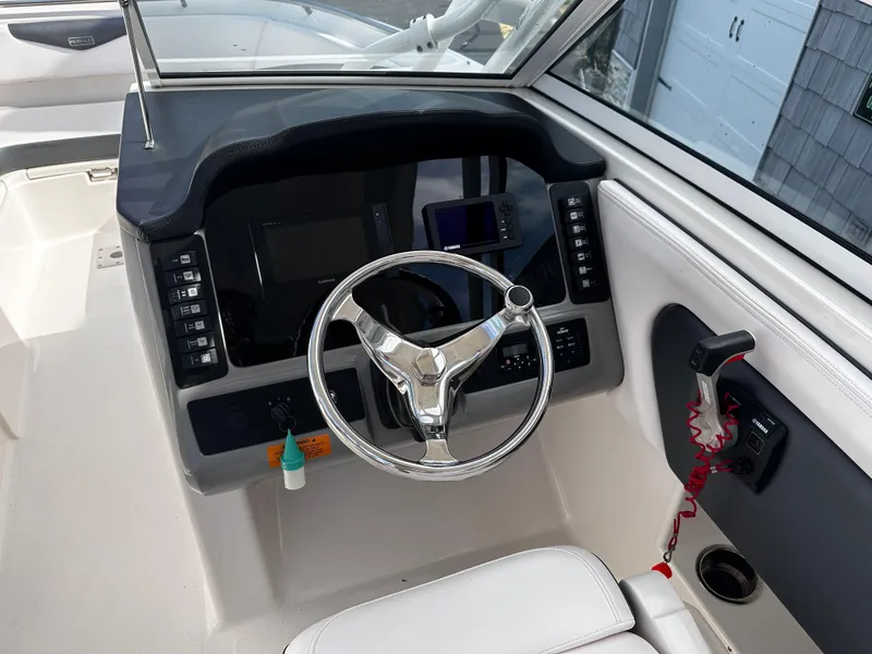 Slide: The Image of 2019 Robalo R247 Dual Console boat dashboard with steering wheel and controls. - 29