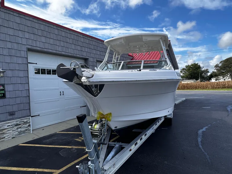 Slide: The Image of 2019 Robalo R247 Dual Console boat on trailer, parked near a garage. - 3