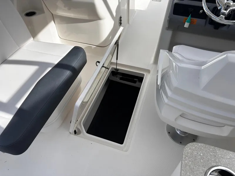 Slide: The Image of 2019 Robalo R247 Dual Console boat interior with open storage compartment. - 30