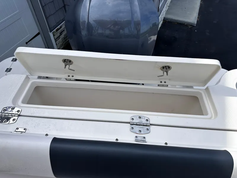 Slide: The Image of Open storage compartment on 2019 Robalo R247 Dual Console boat. - 31