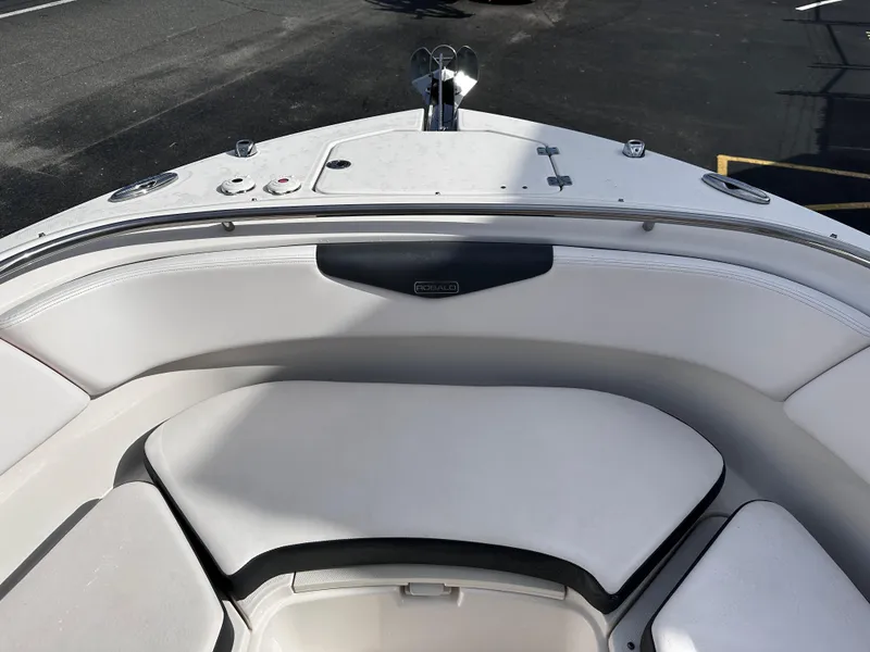 Slide: The Image of 2019 Robalo R247 Dual Console boat with white cushioned seating in the bow area. - 8